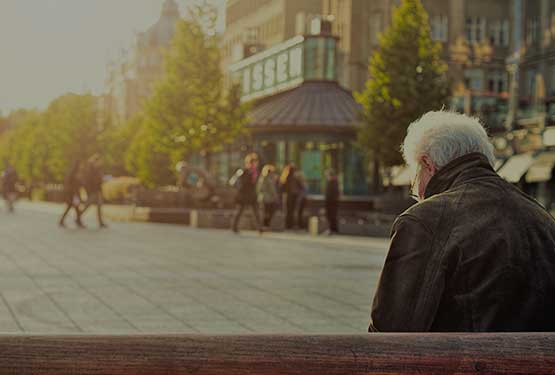 Ηλικιωμένος κύριος σε πρώτο πλάνο και στο βάθος κόσμος